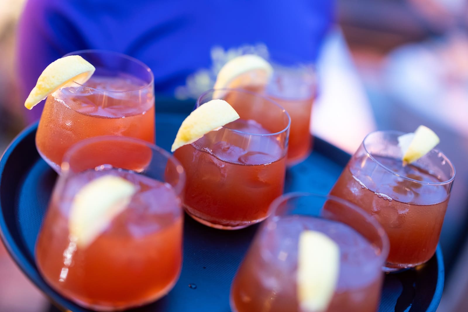 A tray of cocktails garnished with lemon